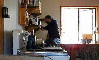 Richard, our caretaker, installs a tankless water heater in our kitchen